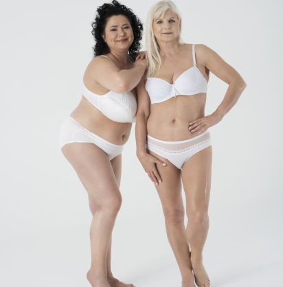 Zwei Frauen unterschiedlicher Statur posieren zusammen in Unterwäsche